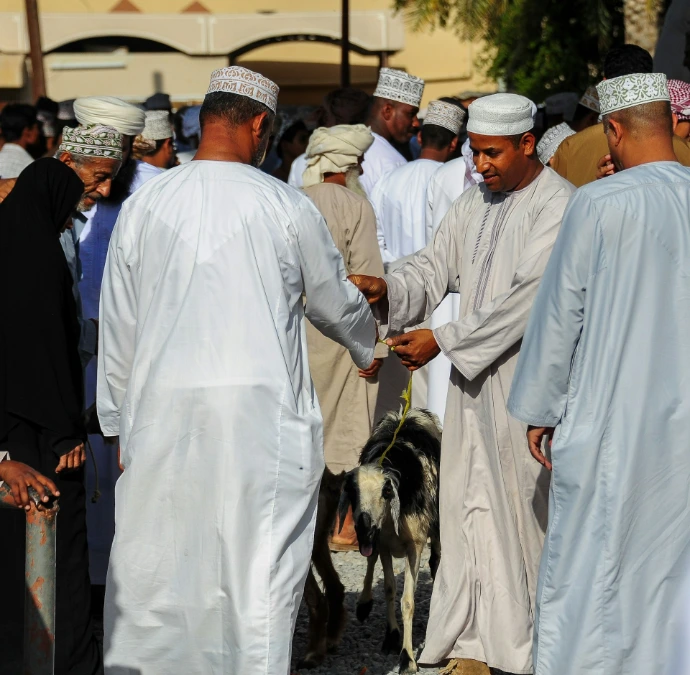 Men in traditional clothing with a goat